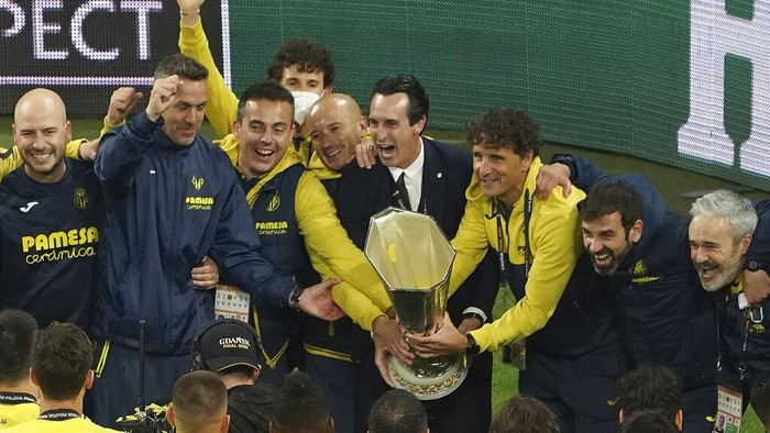Villarreal's manager Unai Emery, centre right, celebrates with the trophy and his team members after the Europa League final soccer match between Manchester United and Villarreal in Gdansk, Poland, Wednesday May 26, 2021. (Aleksandra Szmigiel, Pool via AP)