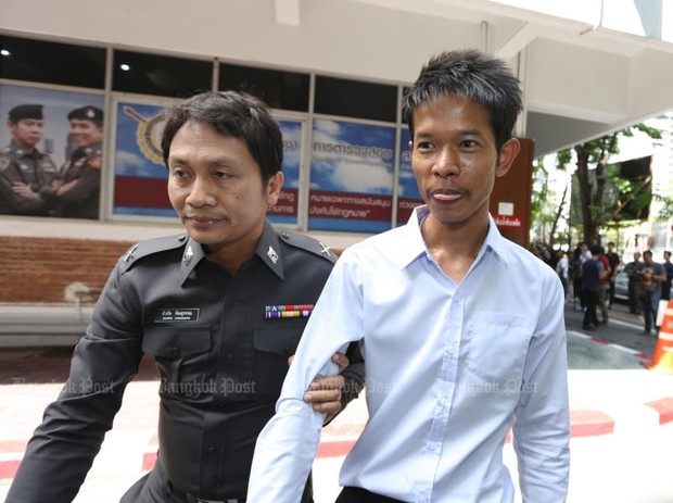 Suankularb Wittayalai School teacher Sarot Meephai, right, is being escorted by a police officer (Photo by Jiraporn Kuhakan)