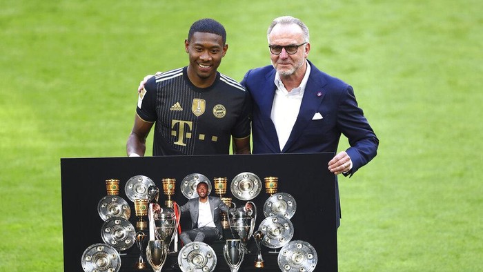 Bayerns David Alaba, left, poses with Bayern Munich CEO Karl Heinz Rummenigge prior to the start of the Bundesliga soccer match between Bayern Munich and FC Augsburg at the Allianz Arena stadium in Munich, Germany, Saturday, May 22, 2021. (AP Photo/Matthias Schrader, Pool)