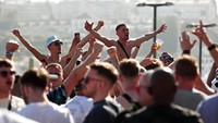 Pendukung Manchester City bernyanyi dan meneriakkan yel-yel di luar bar di tepi sungai Douro, Porto, Portugal, 