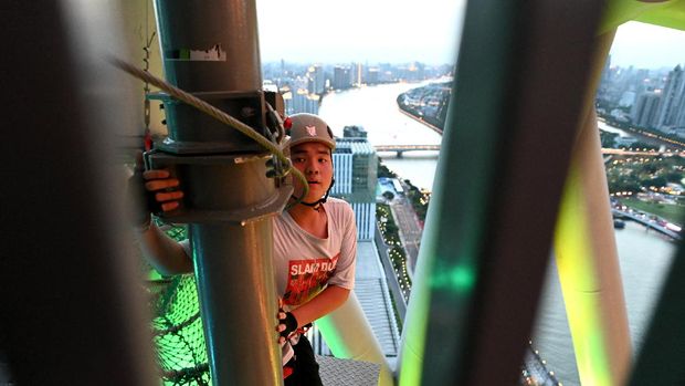 Wisata Menantang Adrenalin di Menara TV Tertinggi China This photo taken on May 23, 2021 shows a visitor at the adventure park of Canton Tower in Guangzhou, China's southern Guangdong province. - Walking tightropes, rappelling down a four-storey-high rope tunnel, sitting in a dangling basket 58 floors high -- tourists have been steeling their nerves for adrenaline-filled challenges in a new assault course at the top of China's tallest TV tower. (Photo by NOEL CELIS / AFP)