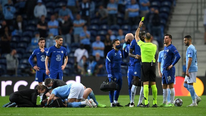 PORTO, PORTUGAL - MAY 29: Antonio Ruediger of Chelsea receives a yellow card as Kevin De Bruyne of Manchester City receives medical attention during the UEFA Champions League Final between Manchester City and Chelsea FC at Estadio do Dragao on May 29, 2021 in Porto, Portugal. (Photo by David Ramos/Getty Images)