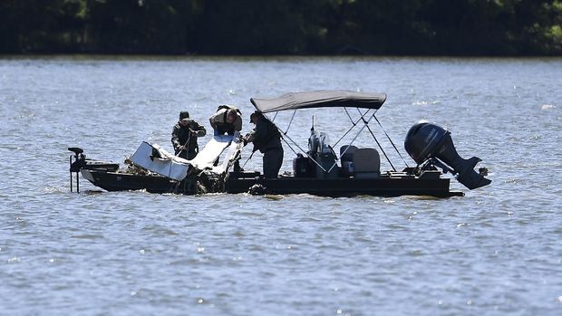 Emergency personnel remove debris from a plane crash in Percy Priest Lake Sunday, May 30, 2021, near Smyrna, Tenn. A small jet carrying seven people crashed Saturday, and authorities indicated that no one on board survived. (George Walker IV/The Tennessean via AP)