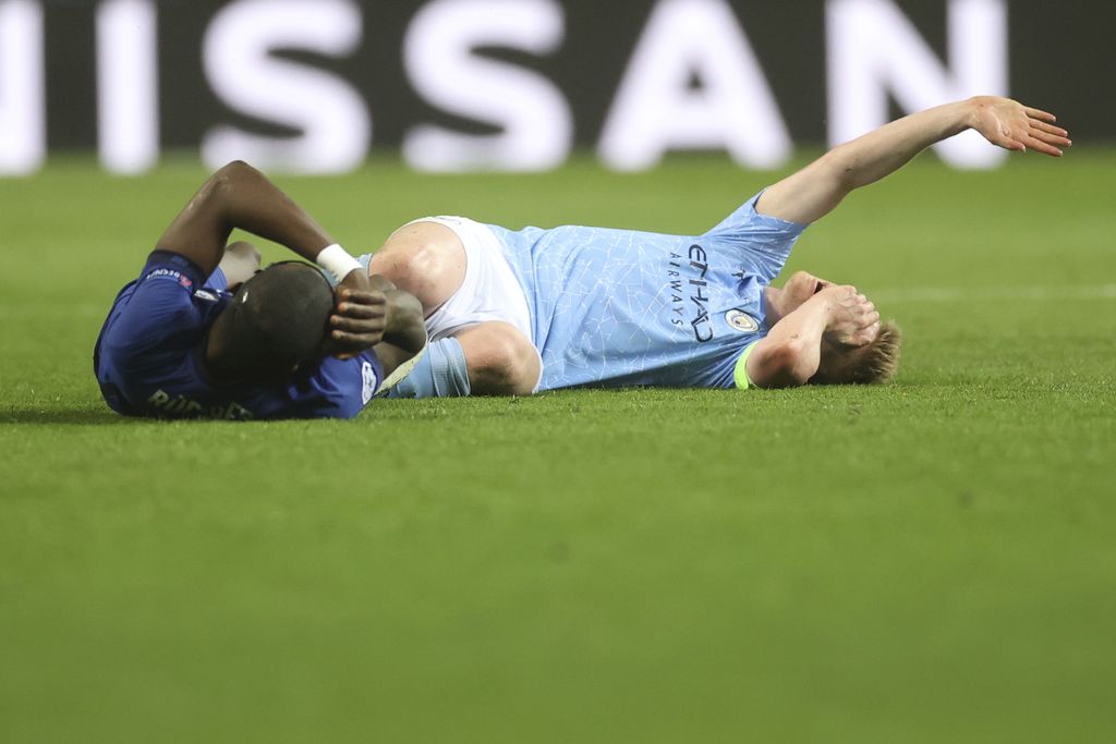 Chelsea's Antonio Rudiger, left and Manchester City's Kevin De Bruyne fall after challenge during the Champions League final soccer match between Manchester City and Chelsea at the Dragao Stadium in Porto, Portugal, Saturday, May 29, 2021. (Carl Recine/Pool via AP)