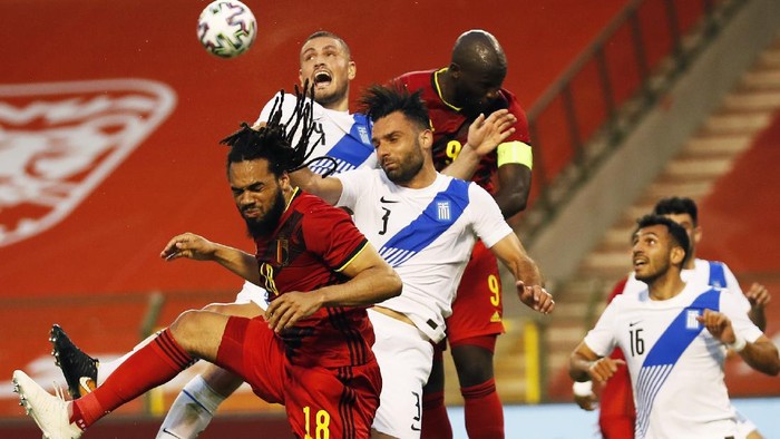 Belgiums Jason Denayer, left, goes up against Greeces Giorgos Tzavellas, third left, during the international friendly soccer match between Belgium and Greece at the King Baudouin stadium in Brussels, Thursday, June 3, 2021. (AP Photo/Francisco Seco)