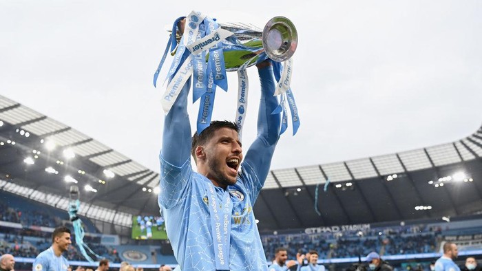 MANCHESTER, ENGLAND - MAY 23: Ruben Dias of Manchester City celebrates with the Premier League Trophy as Manchester City are presented with the Trophy as they win the league following the Premier League match between Manchester City and Everton at Etihad Stadium on May 23, 2021 in Manchester, England. A limited number of fans will be allowed into Premier League stadiums as Coronavirus restrictions begin to ease in the UK. (Photo by Michael Regan/Getty Images)