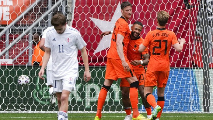 Netherlands Wout Weghorst, rear left, and Netherlands Frenkie de Jong, rear right, run to hug Netherlands Memphis Depay who scored his sides first goal with a penalty during the friendly soccer match between The Netherlands and Georgia, in the run-up to the Euro2020 soccer tournament, in Enschede, eastern Netherlands, Sunday, June 6, 2021. (AP Photo/Peter Dejong)