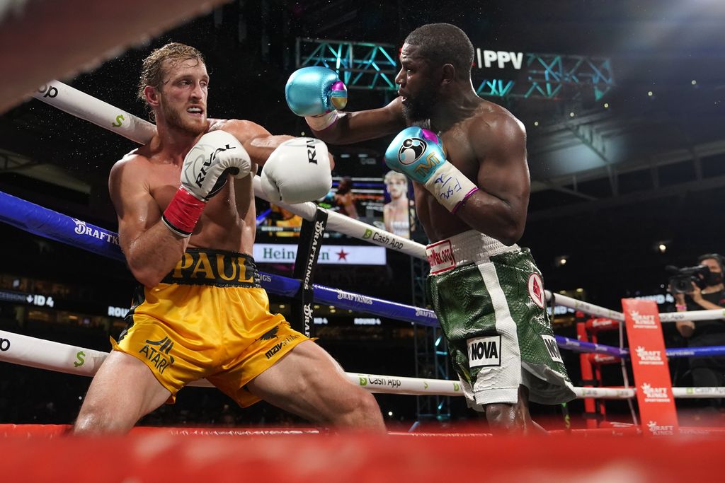 Floyd Mayweather, right, throws a punch at Logan Paul, left, during an exhibition boxing match at Hard Rock Stadium, Sunday, June 6, 2021, in Miami Gardens, Fla. (AP Photo/Lynne Sladky)