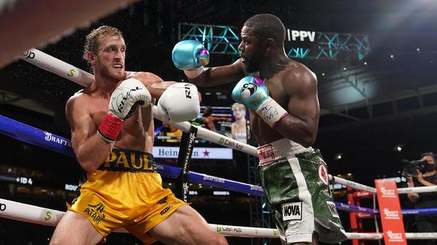 Floyd Mayweather, right, throws a punch at Logan Paul, left, during an exhibition boxing match at Hard Rock Stadium, Sunday, June 6, 2021, in Miami Gardens, Fla. (AP Photo/Lynne Sladky)