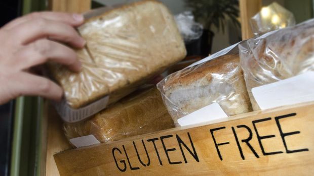 A woman hand picks up a Gluten Free loaf of bread.