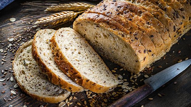 Healthy food: wholegrain and seeds sliced bread shot on rustic wooden table. Predominant color is brown. High resolution 42Mp studio digital capture taken with Sony A7rII and Sony FE 90mm f2.8 macro G OSS lens