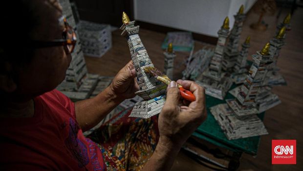 Sugito (68) menyelesaikan pembuatan miniatur Monas dari kertas koran bekas di Bank Sampah Tri Alam Lestari, Pesanggrahan, Jakarta Selatan, Senin (7/6/2021). CNN Indonesia/Adi Maulana Ibrahim