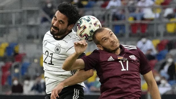 Germany's Ilkay Gundogan, left, and Latvia's Arturs Zjuzins challenge for the all during the international friendly soccer match between Germany and Latvia in Duesseldorf, Germany, Monday, June 7, 2021 (AP Photo/Martin Meissner)