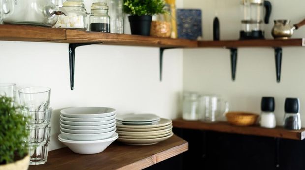 Dish and decorations on open wooden shelves in white kitchen