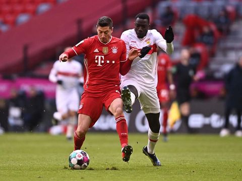 MUNICH, GERMANY - MARCH 20: Robert Lewandowski of FC Bayern Muenchen is challenged by Silas Wamangituka of VfB Stuttgart  during the Bundesliga match between FC Bayern Muenchen and VfB Stuttgart at Allianz Arena on March 20, 2021 in Munich, Germany. Sporting stadiums around Germany remain under strict restrictions due to the Coronavirus Pandemic as Government social distancing laws prohibit fans inside venues resulting in games being played behind closed doors. (Photo by Lukas Barth-Tuttas - Pool/Getty Images)