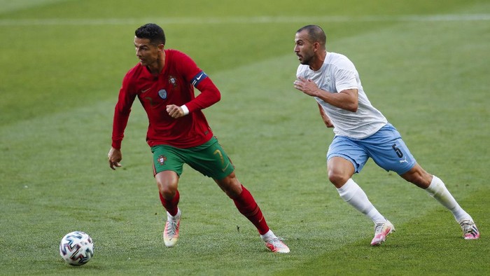 Portugals Cristiano Ronaldo, left, runs with the ball next to Israels Orel Dgani during the international friendly soccer match between Portugal and Israel at the Alvalade stadium in Lisbon, Wednesday, June 9, 2021. (AP Photo/Armando Franca)