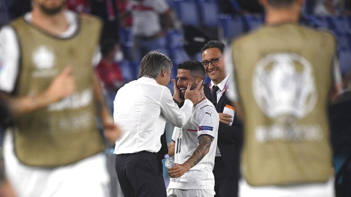 Italys Lorenzo Insigne, right, celebrates with Italys manager Roberto Mancini after scoring his sides third goal during the Euro 2020 soccer championship group A match between Italy and Turkey at the Olympic stadium in Rome, Friday, June 11, 2021. (Alberto Lingria/Pool Photo via AP)