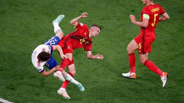 Russia's midfielder Daler Kuzyaev (L) and Belgium's defender Timoty Castagne falls to the ground after hitting each other during the UEFA EURO 2020 Group B football match between Belgium and Russia at the Saint Petersburg Stadium in Saint Petersburg on June 12, 2021. (Photo by ANTON VAGANOV / POOL / AFP)
