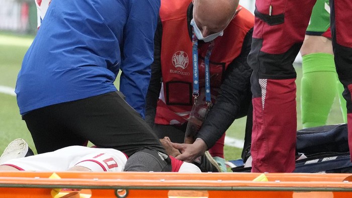 Medics assist Denmarks Christian Eriksen after he collapsed on the pitch during the Euro 2020 soccer championship group B match between Denmark and Finland at Parken Stadium in Copenhagen, Saturday, June 12, 2021. (AP Photo/Martin Meissner, Pool)