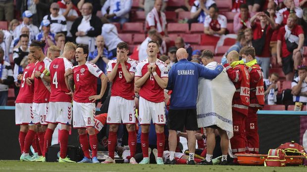 Denmark players react after the collapsing of their teammate Christian Eriksen during the Euro 2020 soccer championship group B match between Denmark and Finland at Parken stadium in Copenhagen, Denmark, Saturday, June 12, 2021. (Friedemann Vogel/Pool via AP)