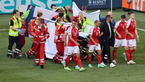 Denmark's players gather as paramedics attend to midfielder Christian Eriksen (not seen) during the UEFA EURO 2020 Group B football match between Denmark and Finland at the Parken Stadium in Copenhagen on June 12, 2021. (Photo by WOLFGANG RATTAY / various sources / AFP)