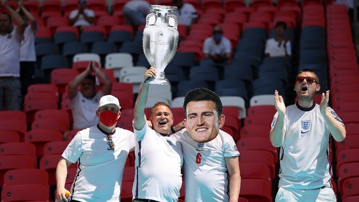 LONDON, ENGLAND - JUNE 13: England fans raise a cardboard UEFA Euro 2020 trophy and wear a Harry Maguire mask in the stand prior to the UEFA Euro 2020 Championship Group D match between England and Croatia at Wembley Stadium on June 13, 2021 in London, England. (Photo by Carl Recine - Pool/Getty Images)