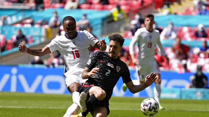 Englands Raheem Sterling, left, scores the opening goal past Croatias Sime Vrsaljko during the Euro 2020 soccer championship group D match between England and Croatia at Wembley stadium in London, Sunday, June 13, 2021. (AP Photo/Frank Augstein, Pool)