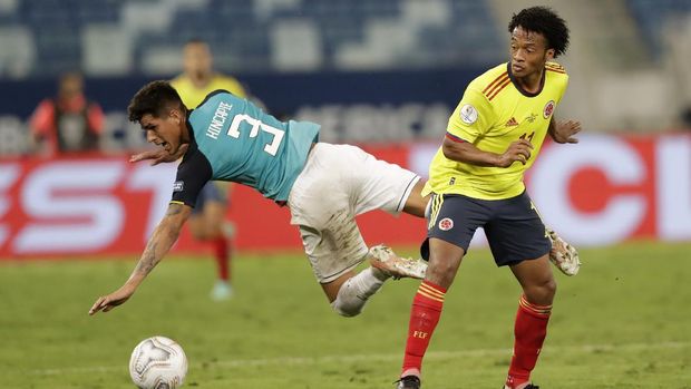 Ecuador's Piero Hincapie, left, and Colombia's Juan Cuadrado battle for the ball during a Copa America soccer match at Arena Pantanal stadium in Cuiaba, Brazil, Sunday, June 13, 2021. (AP Photo/Andre Penner)