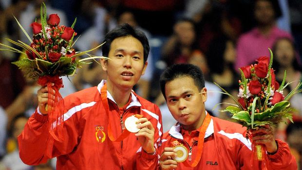 Markis Kido (R) and Hendra Setiawan of Indonesia celebrate with their gold medals in the men's badminton doubles event of the 2008 Beijing Olympic Games in Beijing on August 16, 2008. Kido and Setiawan beat Cai Yun and Fu Haifeng of China 12-21, 21-11, 21-16. AFP PHOTO/GOH CHAI HIN (Photo by GOH CHAI HIN / AFP)