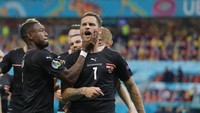 Ujung-ujungnya, kapten Austria David Alaba tampak mencekik mulut Arnautovic. (Foto: AP/Robert Ghement)