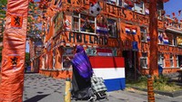 Seorang warga beraktivitas di kawasan The Hague, Belanda, yang dihiasi dengan berbagai ornamen dukungan untuk Timnas Belanda, Senin (14/6/2021).