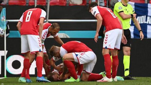 Denmark players help Denmark's midfielder Christian Eriksen after he collapsed before the medics arrive during the UEFA EURO 2020 Group B football match between Denmark and Finland at the Parken Stadium in Copenhagen on June 12, 2021. (Photo by Jonathan NACKSTRAND / various sources / AFP)