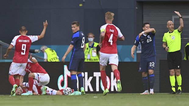 Referee Anthony Taylor, right, calls for medics to enter the field after Denmark's Christian Eriksen collapsed on the pitch during the Euro 2020 soccer championship group B match between Denmark and Finland at Parken Stadium in Copenhagen, Saturday, June 12, 2021. (Stuart Franklin/Pool via AP)