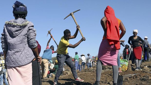 A man uses a pickaxe to dig as fortune seekers flock to the village after pictures and videos were shared on social media showing people celebrating after finding what they believe to be diamonds, in the village of KwaHlathi outside Ladysmith, in KwaZulu-Natal province, South Africa, June 14, 2021. REUTERS/Siphiwe Sibeko