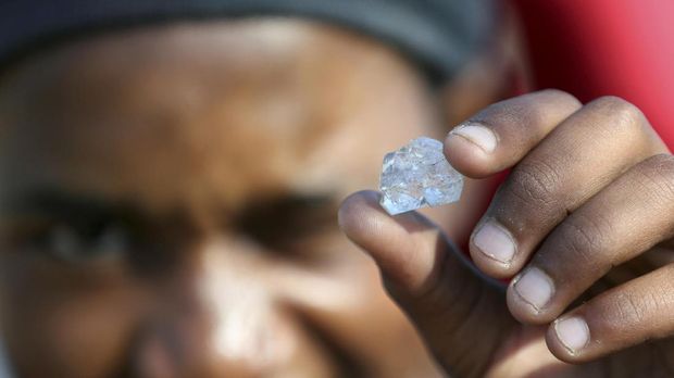A man shows an unidentified stone as fortune seekers flock to the village after pictures and videos were shared on social media showing people celebrating after finding what they believe to be diamonds, in the village of KwaHlathi outside Ladysmith, in KwaZulu-Natal province, South Africa, June 14, 2021. REUTERS/Siphiwe Sibeko TPX IMAGES OF THE DAY