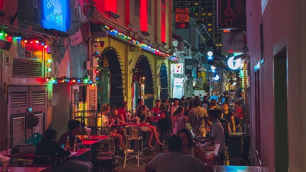 Haji Lane, Singapore In the middle east inspired Haji Lane pub and shopping street in Singapore people rest and drink beers at the many bars or just walk along the street and do window shopping. Seen at night.