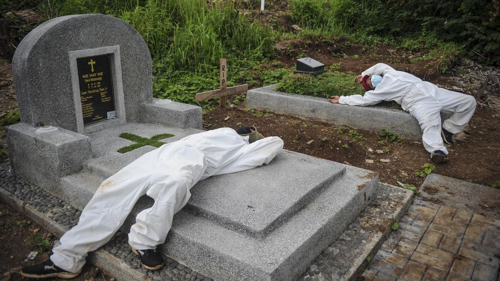 Sejumlah tenaga pikul beristirahat setelah memakamkan jenazah dengan protokol COVID-19 di TPU Cikadut, Bandung, Jawa Barat, Selasa (15/6/2021). Petugas pikul jenazah mengatakan, pemakaman jenazah dengan protokol COVID-19 di TPU Cikadut mengalami peningkatan sebanyak 20 hingga 30 jenazah per hari dibandingkan dengan bulan lalu yang hanya lima hingga delapan jenazah per hari. ANTARA FOTO/Raisan Al Farisi/foc.