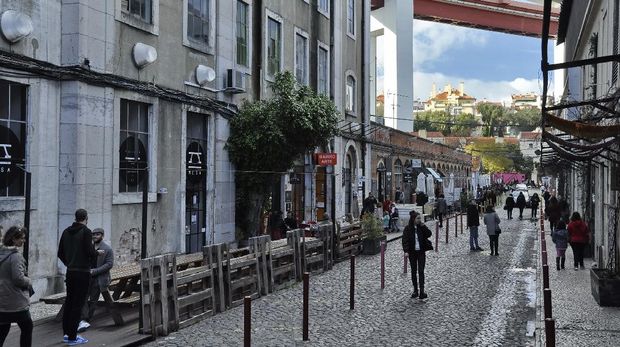 Rua Rodrigues de Faria, Lisbon Lisbon, Portugal - December 29, 2017: View of the Rua Rodrigues de Faria in the LX Factory community space under the 25th of April Bridge