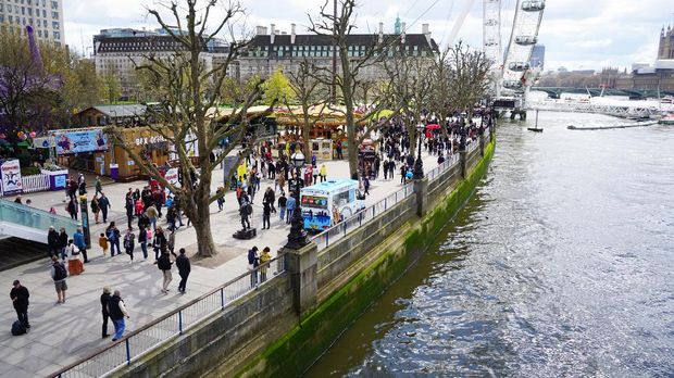 South Bank, London London, England, UK - April 17, 2016: People enjoying the fair ground atmosphere at London Southbank by the river Thames on a sunny Spring day.