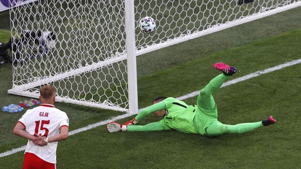 Poland's goalkeeper Wojciech Szczesny scores an own goal during the Euro 2020 soccer championship group E match between Poland and Slovakia at Gazprom arena stadium in St. Petersburg, Russia, Monday, June 14, 2021. (Anton Vaganov/Pool via AP)