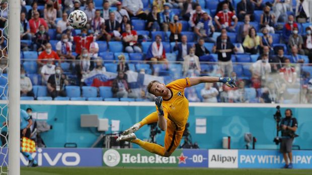 Finland's goalkeeper Lukas Hradecky watches the ball as Russia's Aleksei Miranchuk scores the opening goal of his team during the Euro 2020 soccer championship group B match between Russia and Finland at the Saint Petersburg stadium, in St. Petersburg, Russia, Wednesday, June 16, 2021. (Evgenia Novozhenina/Pool via AP)
