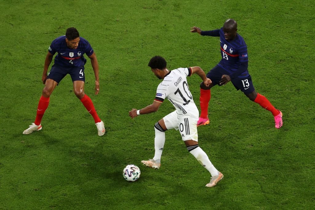 MUNICH, GERMANY - JUNE 15: Serge Gnabry of Germany is closed down by Raphael Varane of France during the UEFA Euro 2020 Championship Group F match between France and Germany at Football Arena Munich on June 15, 2021 in Munich, Germany. (Photo by Matthias Hangst/Getty Images)