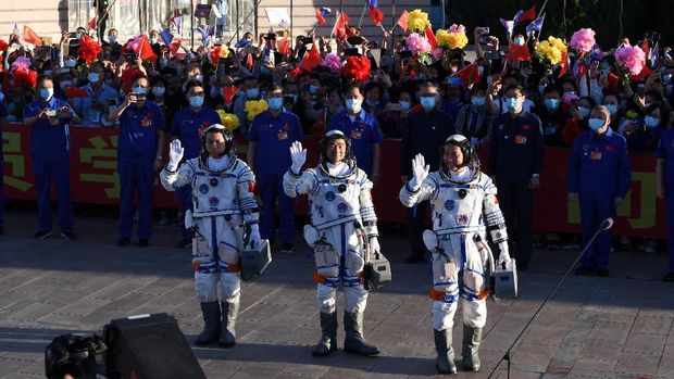 Astronauts Nie Haisheng (R), Liu Boming (C) and Tang Hongbo wave during a departure ceremony before boarding the Shenzhou-12 spacecraft before lift off on a Long March-2F carrier rocket at the Jiuquan Satellite Launch Centre in the Gobi desert in northwest China on June 17, 2021. (Photo by GREG BAKER / AFP)