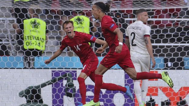 Denmark's Yussuf Poulsen, right, celebrates after scoring his side's first goal during the Euro 2020 soccer championship group B match between Denmark and Belgium at Parken stadium in Copenhagen, Thursday, June 17, 2021. (Friedemann Vogel/Pool via AP)