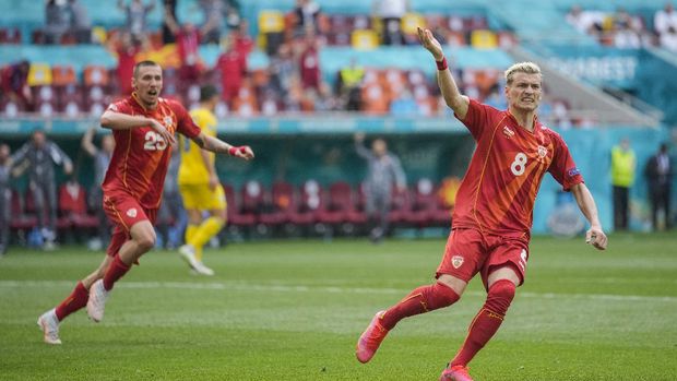 North Macedonia's Ezgjan Alioski, right, celebrates after scoring his side first goal during the Euro 2020 soccer championship group C match between Ukraine and North Macedonia at the National Arena stadium in Bucharest, Romania, Thursday, June 17, 2021. (AP Photo/Vadim Ghirda, Pool)