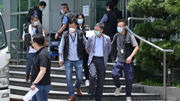 Perlawanan Surat Kabar Apple Daily Pasca Digrebek Polisi Chief Operations Officer Chow Tat Kuen (front 2nd R) is escorted by police from the Apple Daily newspaper offices before being put into a waiting vehicle in Hong Kong on June 17, 2021. (Photo by Anthony WALLACE / AFP)