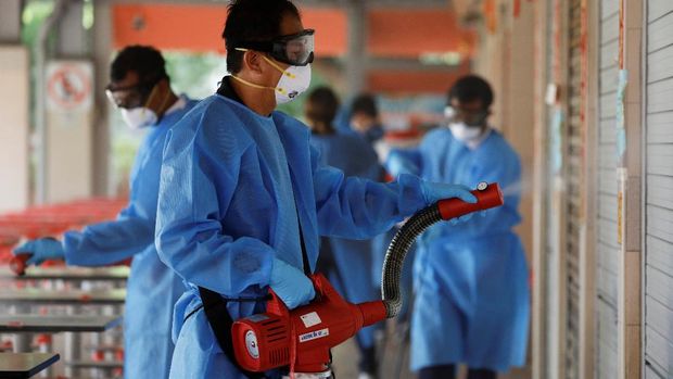 Cleaners disinfect a food center that was closed down after a hawker tested positive for the coronavirus disease (COVID-19), in Singapore, June 16, 2021. REUTERS/Edgar Su