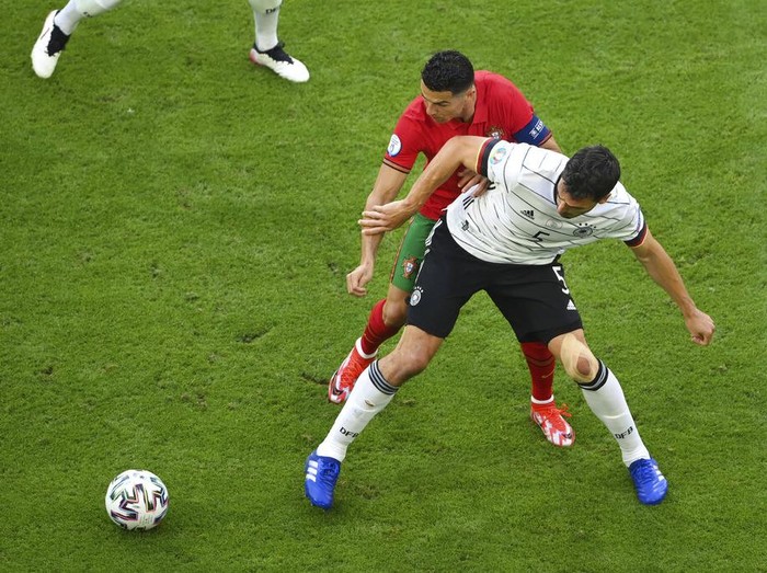 Portugal's Cristiano Ronaldo, top, fights for the ball with Germany's Mats Hummels during the Euro 2020 soccer championship group F match between Portugal and Germany at the football arena stadium in Munich, Saturday, June 19, 2021. (Matthias Hangst/Pool Photo via AP)