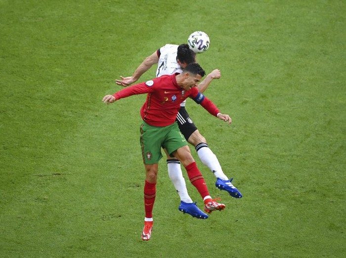 Portugal's Cristiano Ronaldo, foreground, jumps for the ball with Germany's Mats Hummels during the Euro 2020 soccer championship group F match between Portugal and Germany at the football arena stadium in Munich, Saturday, June 19, 2021. (Matthias Hangst/Pool Photo via AP)