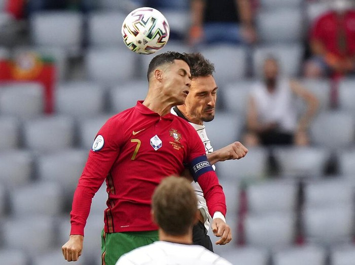 Portugal's Cristiano Ronaldo, left, and Germany's Mats Hummels challenge for the ball during the Euro 2020 soccer championship group F match between Portugal and Germany in Munich, Saturday, June 19, 2021. (AP Photo/Matthias Schrader, Pool)